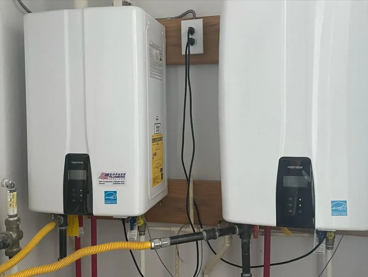 Two white water heaters are sitting next to each other in a room.