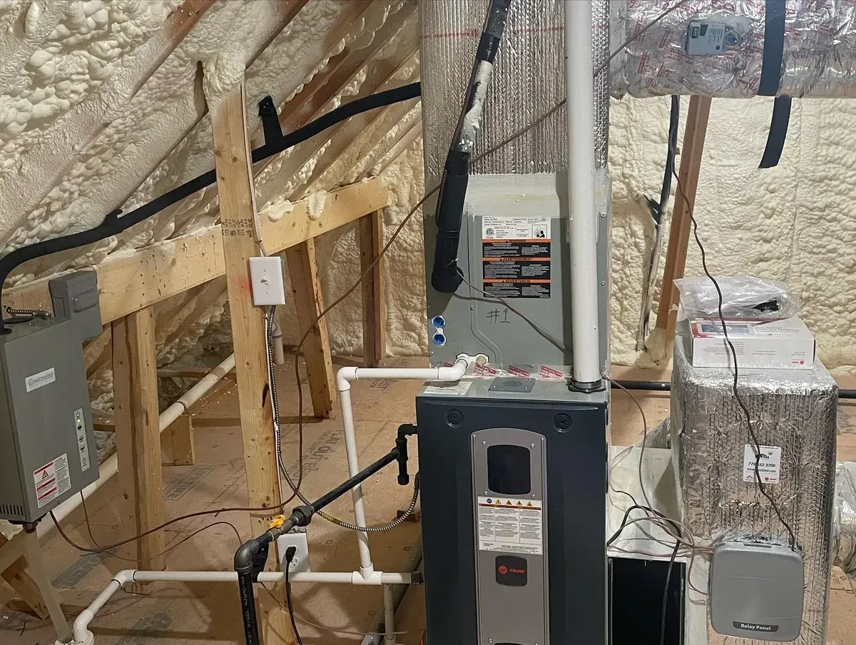 An attic with a furnace , air conditioner , and water heater.