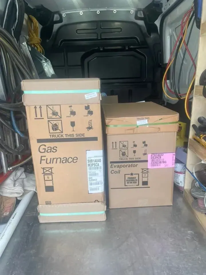 Two boxes of gas furnace are sitting in the back of a van.