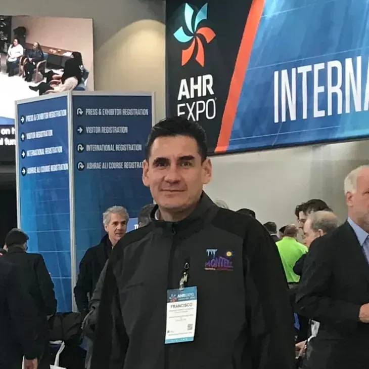 A man stands in front of a sign that says ahr expo