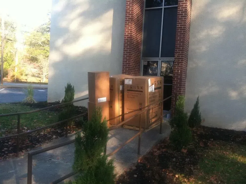 A row of cardboard boxes are sitting outside of a building