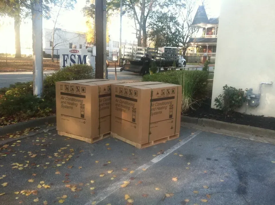 Two boxes in a parking lot with a sign that says fsm on it