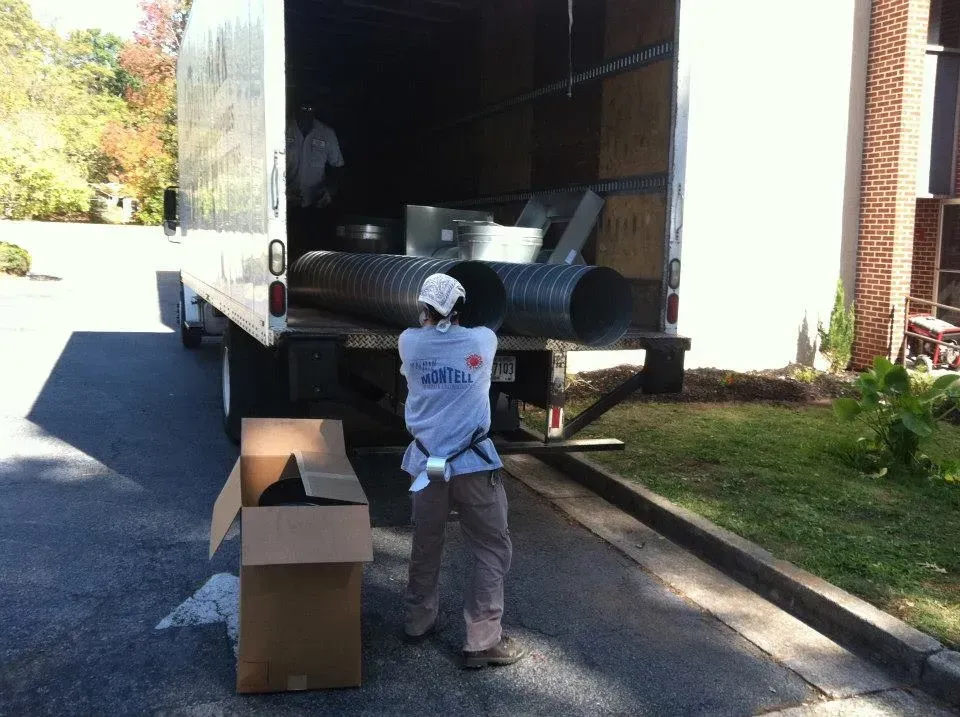 A man is standing in front of a truck with a box in front of it