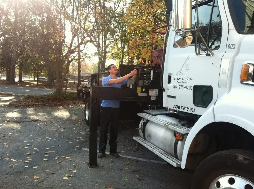 A man is standing next to a large white truck that says u.s. army on the side