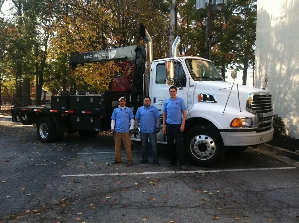 Three men are standing in front of a large truck