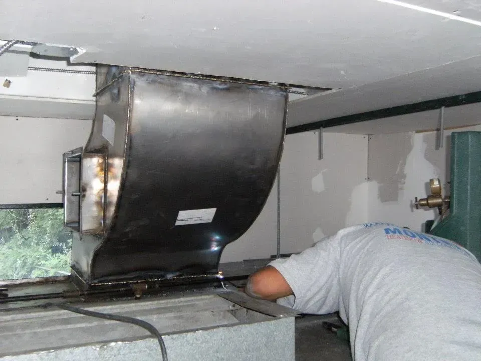 A man in a white shirt is working on a fan