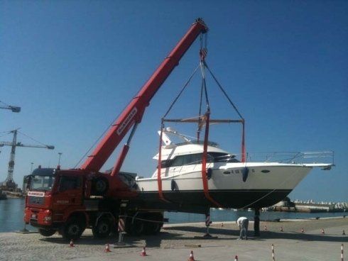 Autogrù in un porto durante il trasporto di una barca