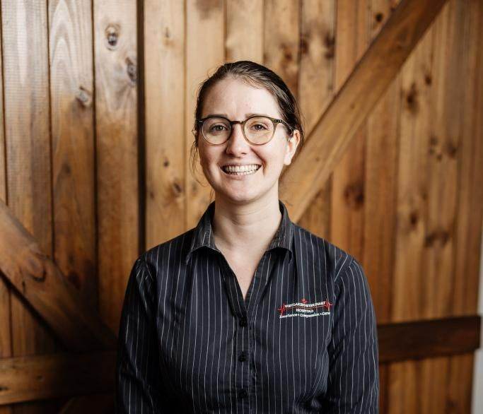 Dr. Allie Is Holding a Dog in Her Arms in Front of A Teepee — Westlakes Veterinary Hospital in Fennell Bay, NSW