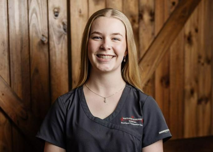Blonde woman in dark scrubs smiles at the camera — Westlakes Veterinary Hospital in Fennell Bay, NSW