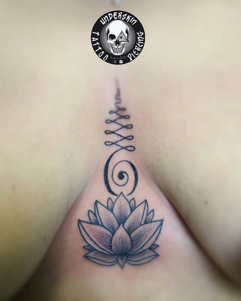 Tatuaggio decorativo con fiore su petto femminile