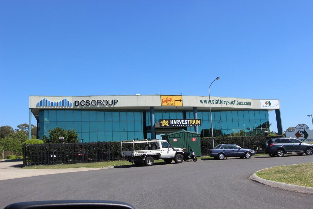 A Large Building With a Lot of Windows and Cars Parked — Peterson Property Valuations In Caloundra West, QLD