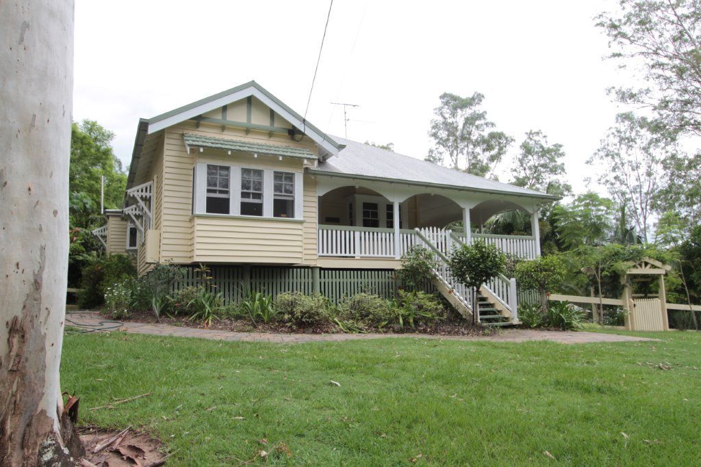 A House With a Porch and Stairs is Surrounded by Grass and Trees — Peterson Property Valuations In Caloundra West, QLD
