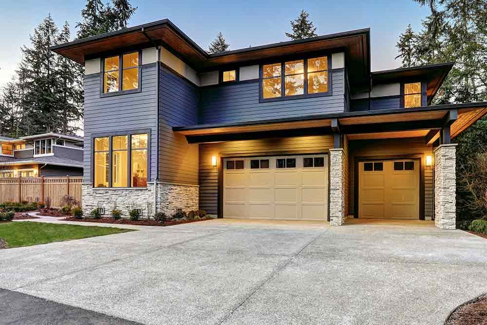 A Large House With Two Garage Doors and a Driveway — Peterson Property Valuations In Caloundra West, QLD