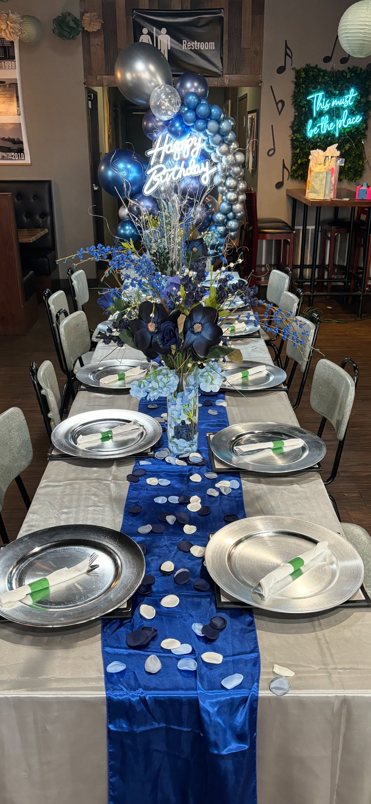A long table with plates and balloons on it.