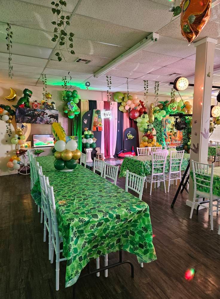 A room filled with tables and chairs and balloons.