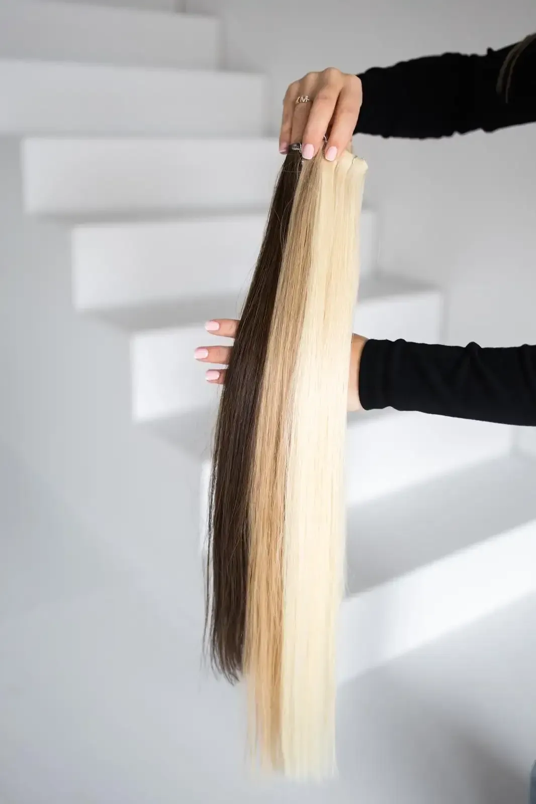 Extensions over de arm van een stylist – SP Hair Groothandel voor professionals