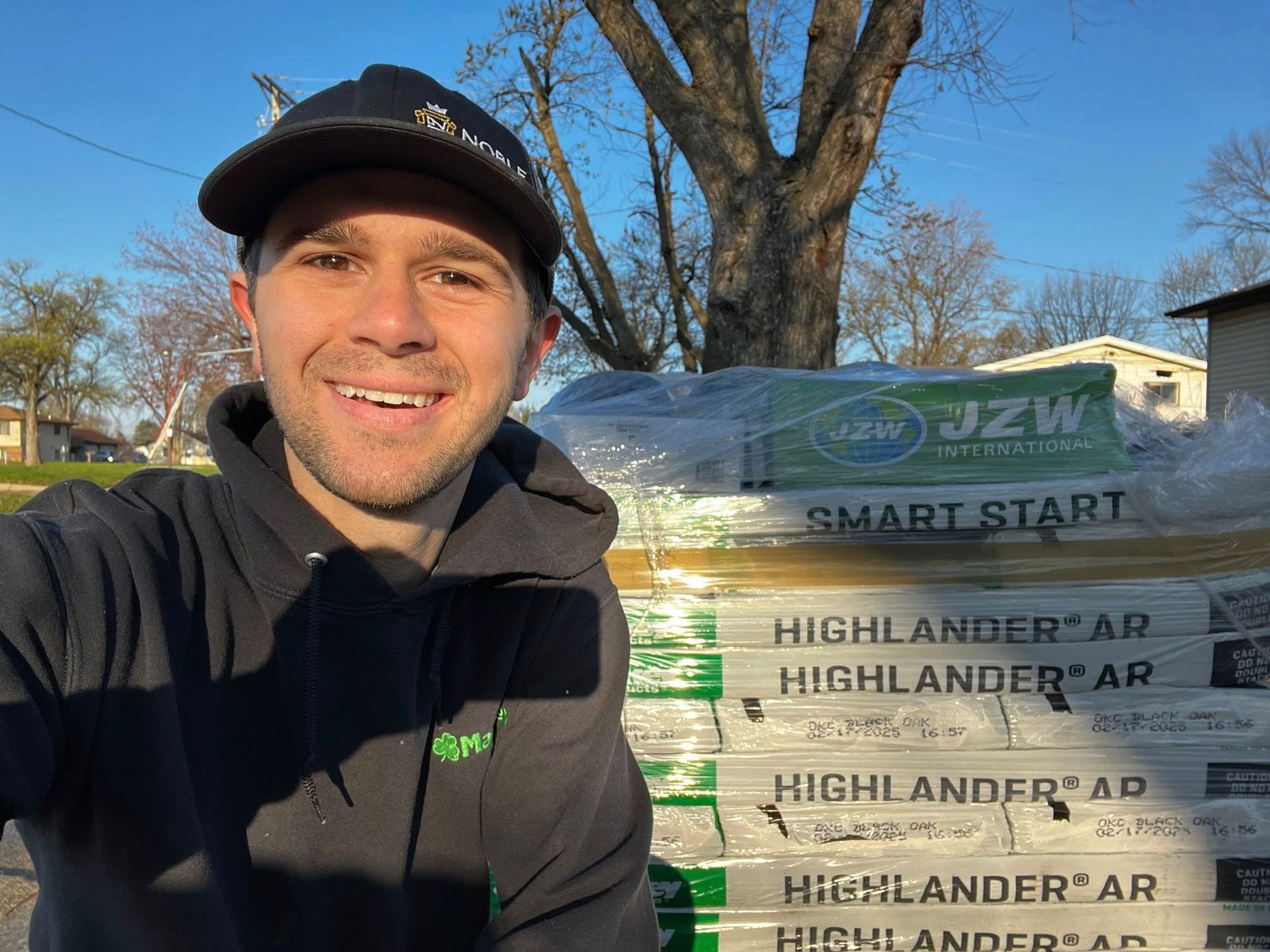 A man is standing in front of a pile of highlander ar.