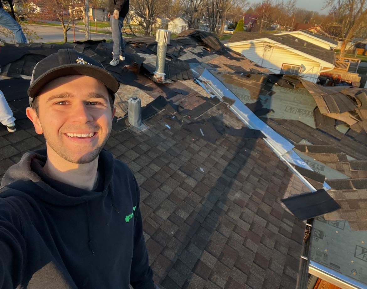 A man is taking a selfie on the roof of a house.