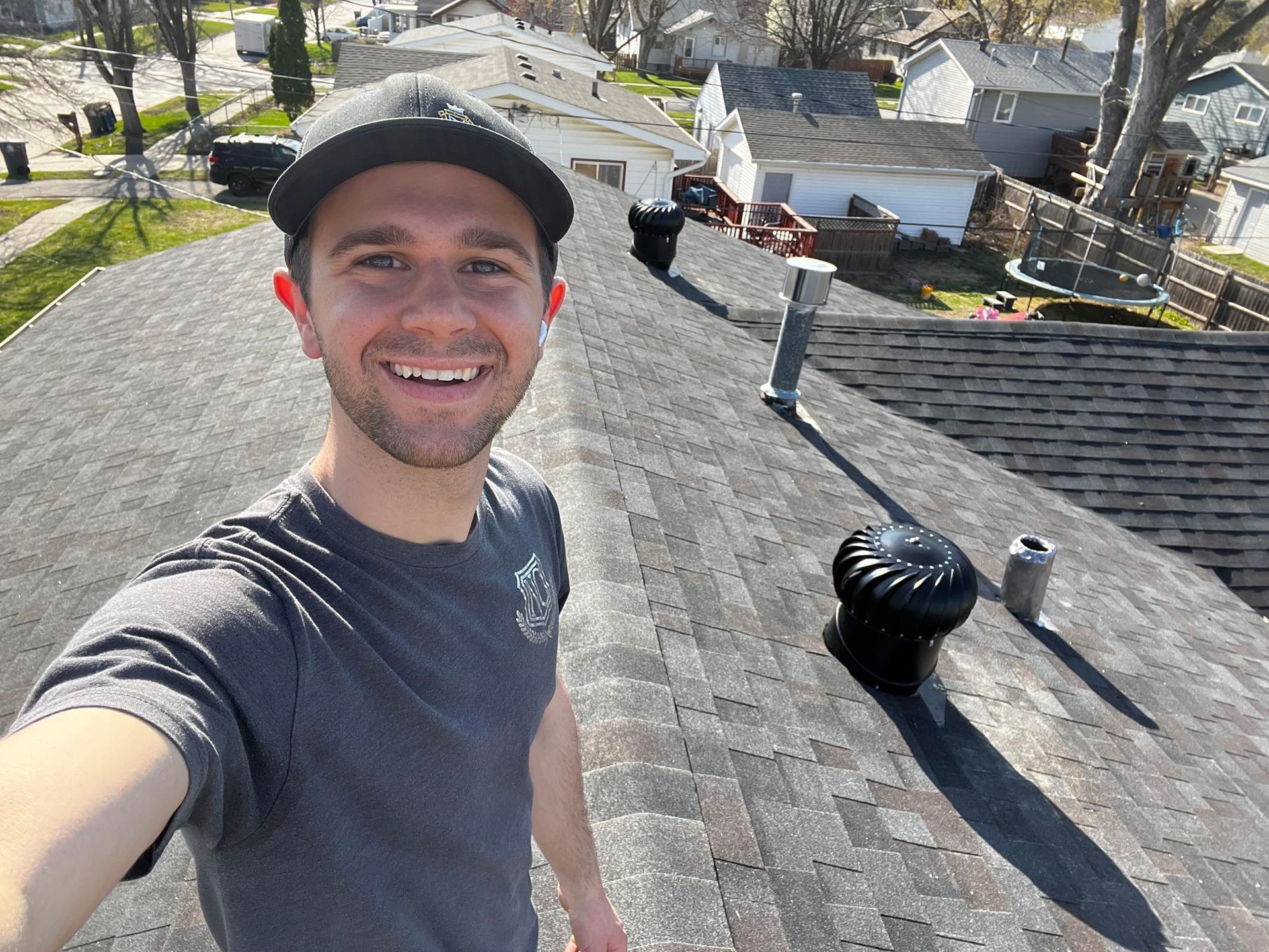 A man is taking a selfie on the roof of a house.