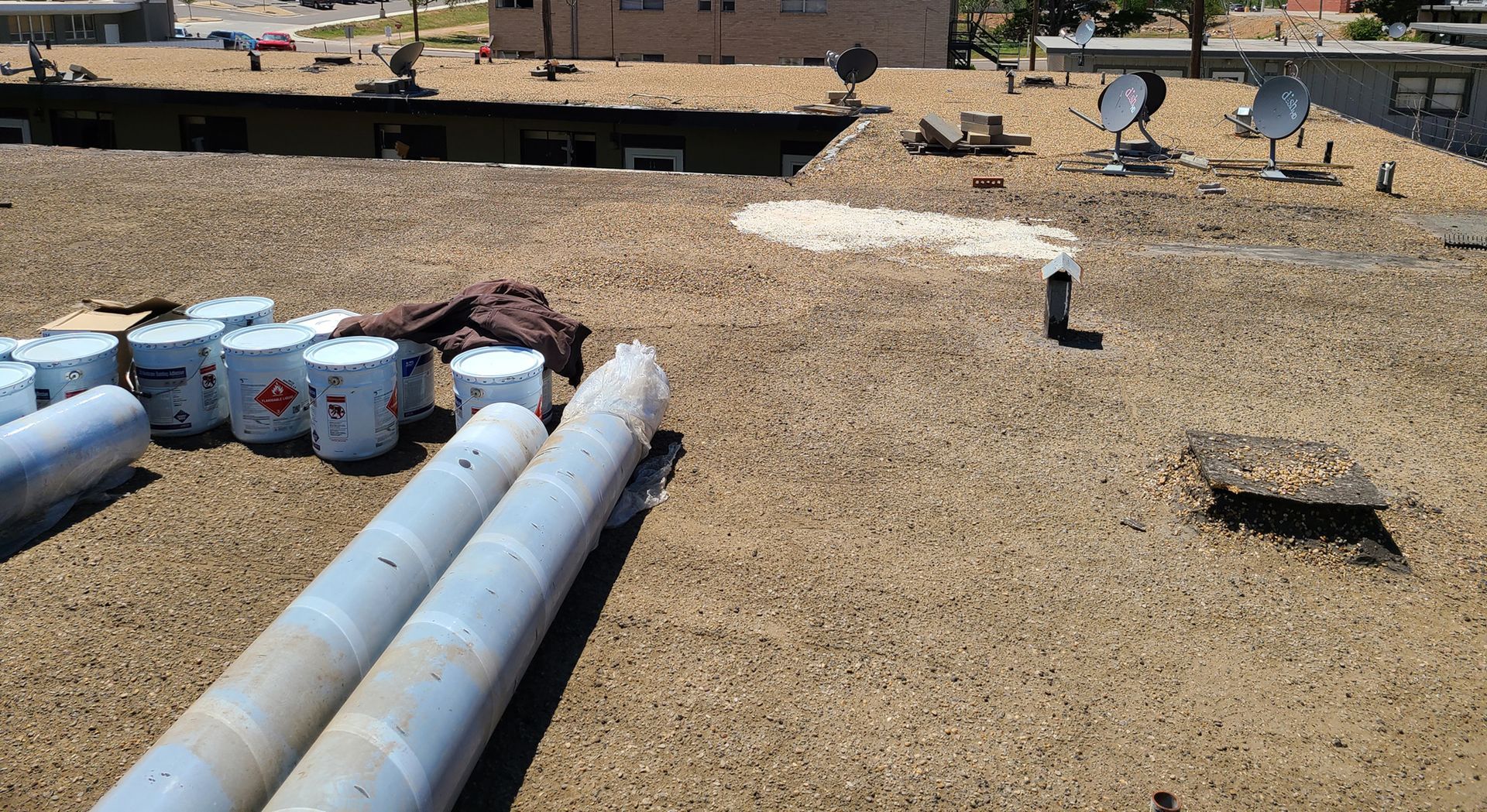 A roof with a lot of pipes and buckets on it