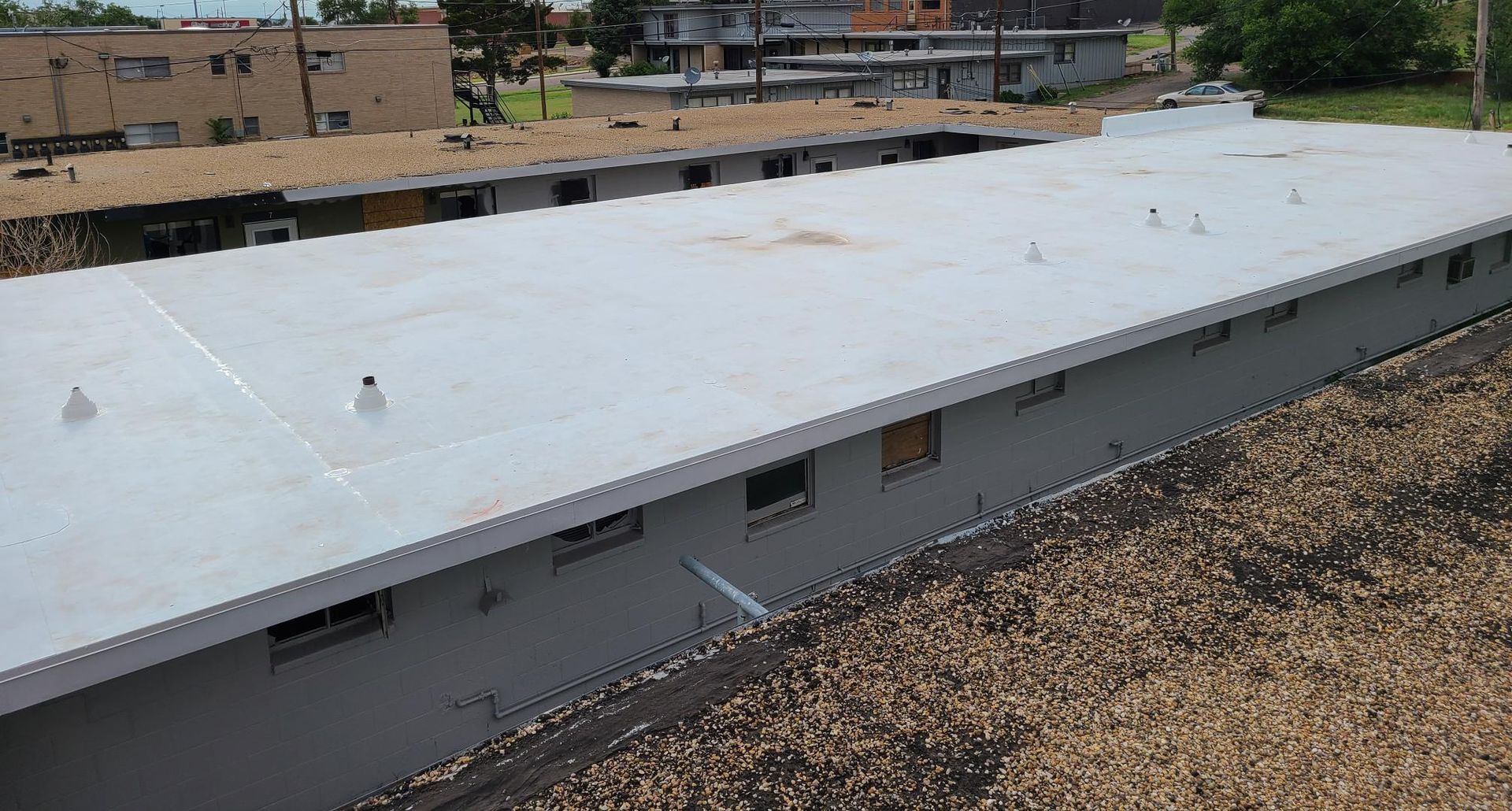 The roof of a building with a white roof is covered in gravel.