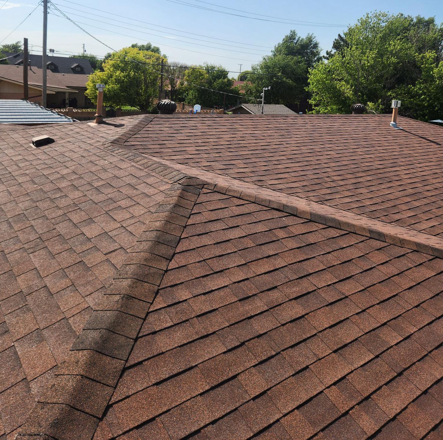 The roof of a house with a brown shingle roof
