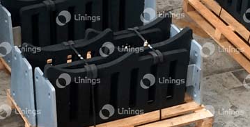A bunch of black boxes are sitting on top of a wooden pallet.