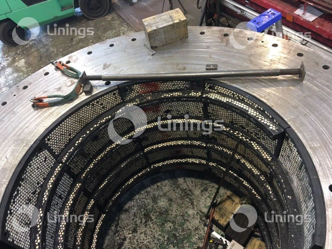 A large metal object is being worked on in a factory.