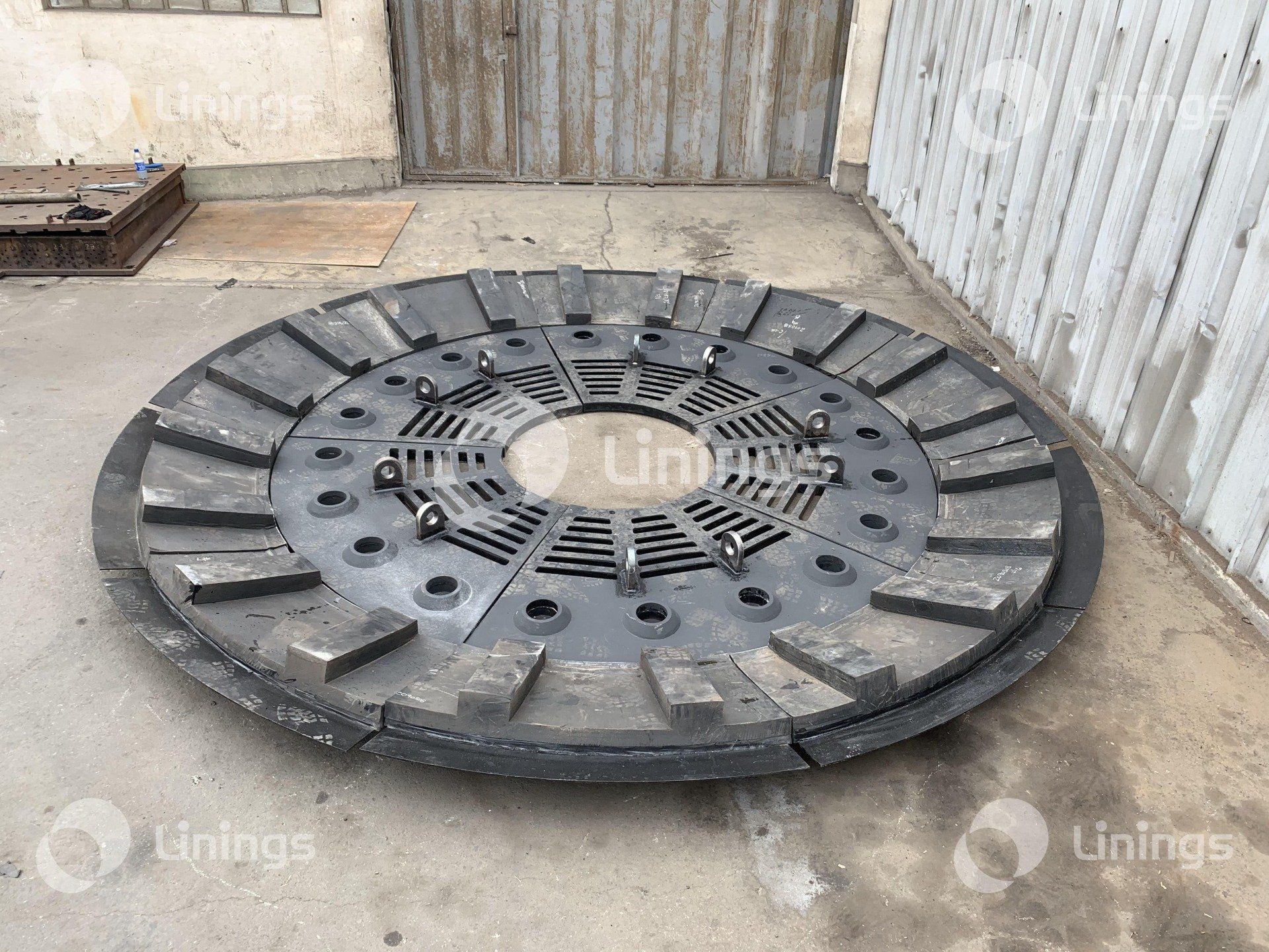 Um grande disco de metal está no chão em frente a um prédio.