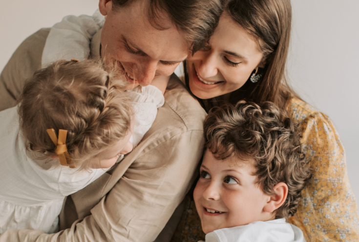 A family is posing for a picture together and smiling.