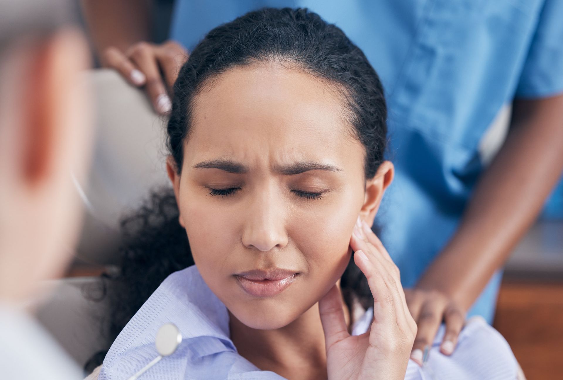 A woman is sitting in a dental chair with a toothache.
