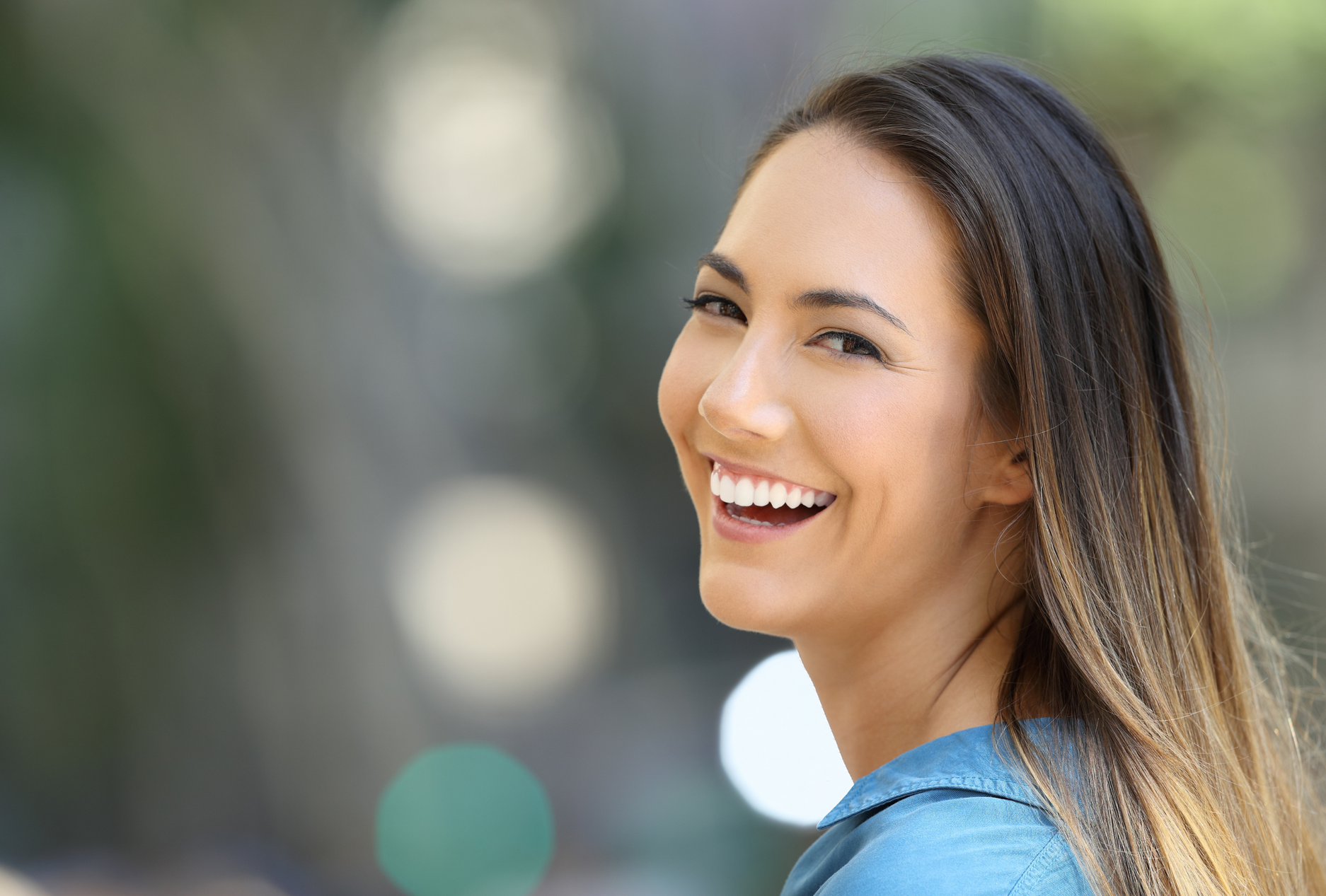 A close up of a woman smiling and looking at the camera.