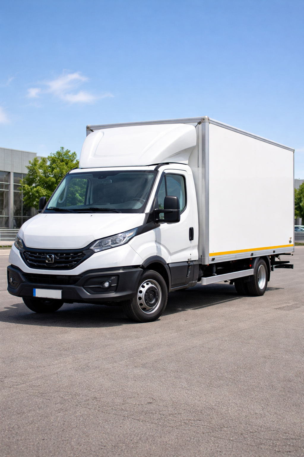 Un camion bianco parcheggiato sull'asfalto sotto un cielo azzurro.