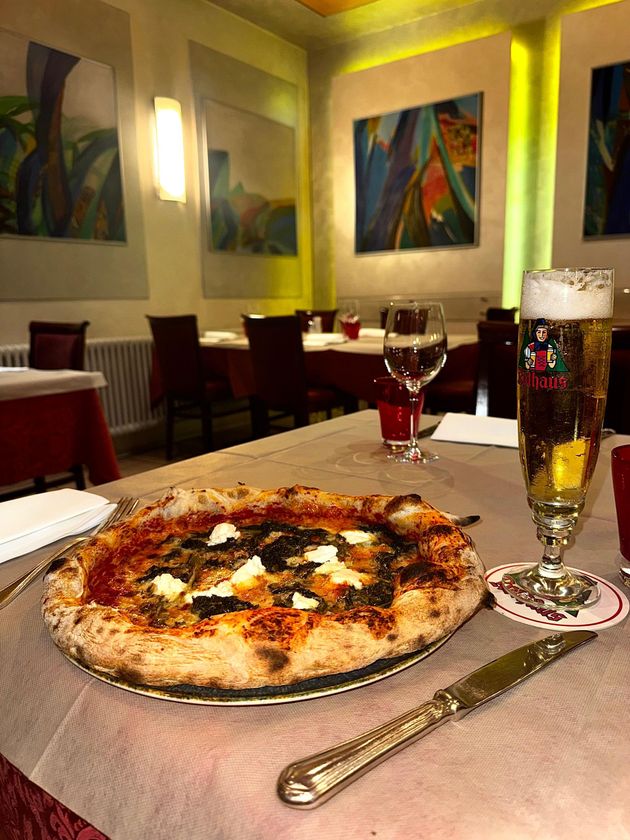Un vassoio d'argento contiene quattro ciotole di rame piene di piatti indiani: riso bianco, curry rosso, curry giallo e curry verde.