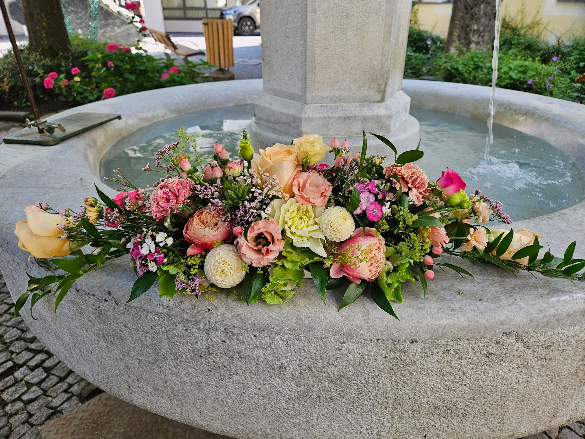 Ein Brunnen ist mit Blumen und Blättern geschmückt.