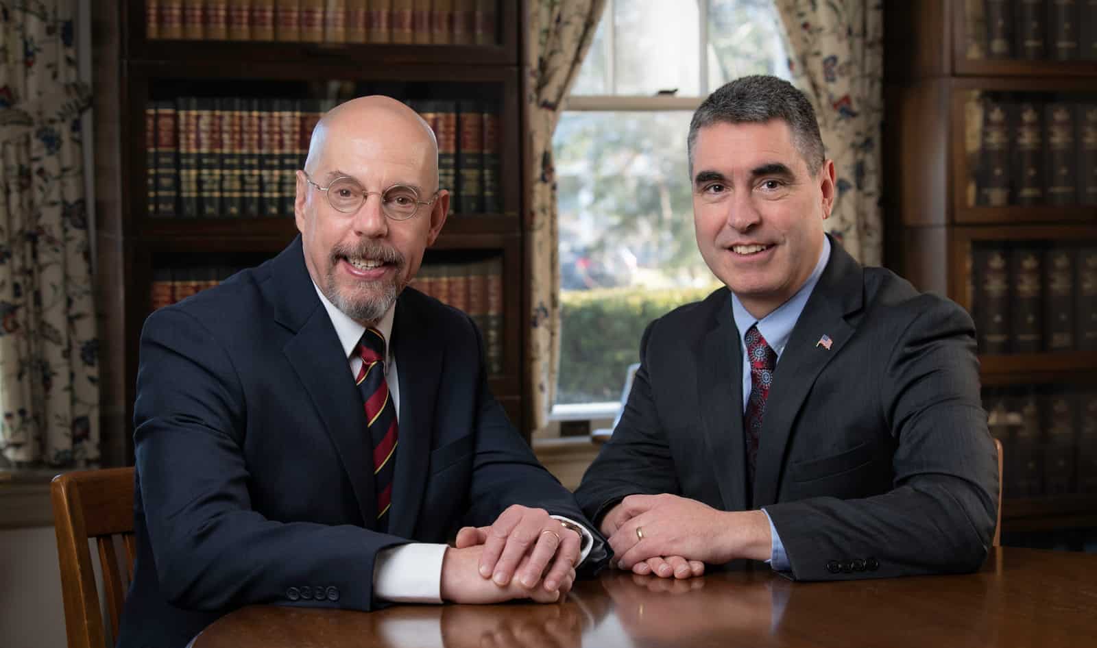 Anthony F. DiPadova Jr. and Alexander W. Scott in suits and ties are sitting at a table.
