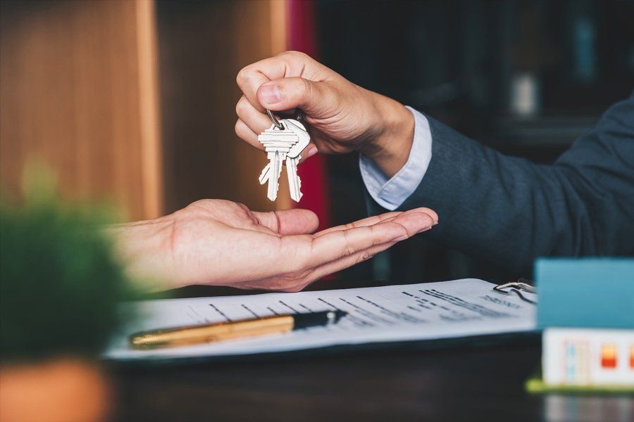 A man is handing a woman a set of keys.