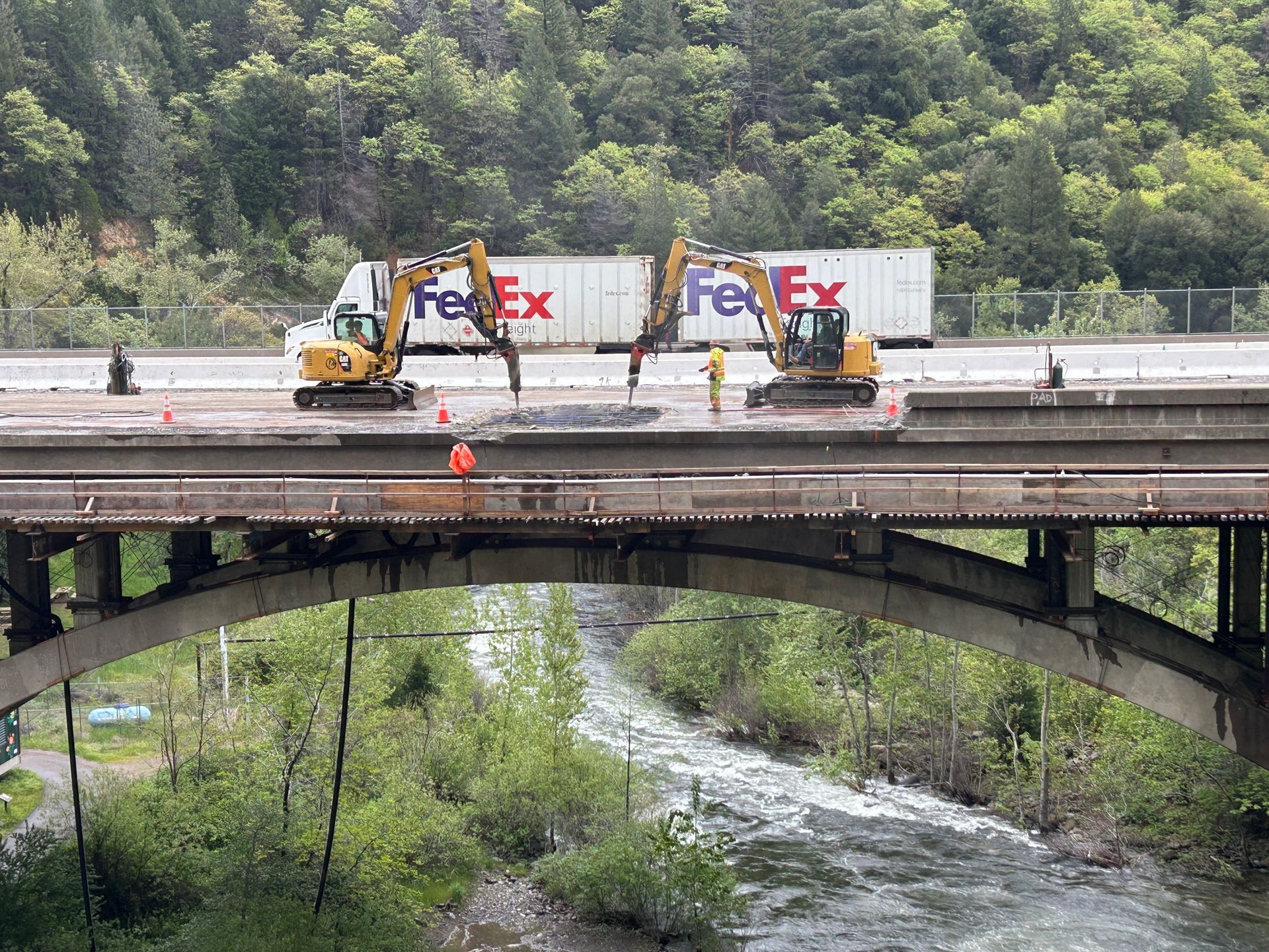 A Man Is Standing on a Wooden Bridge Next to an Excavator — Chicago, IL — Sterling Holloway Demolition