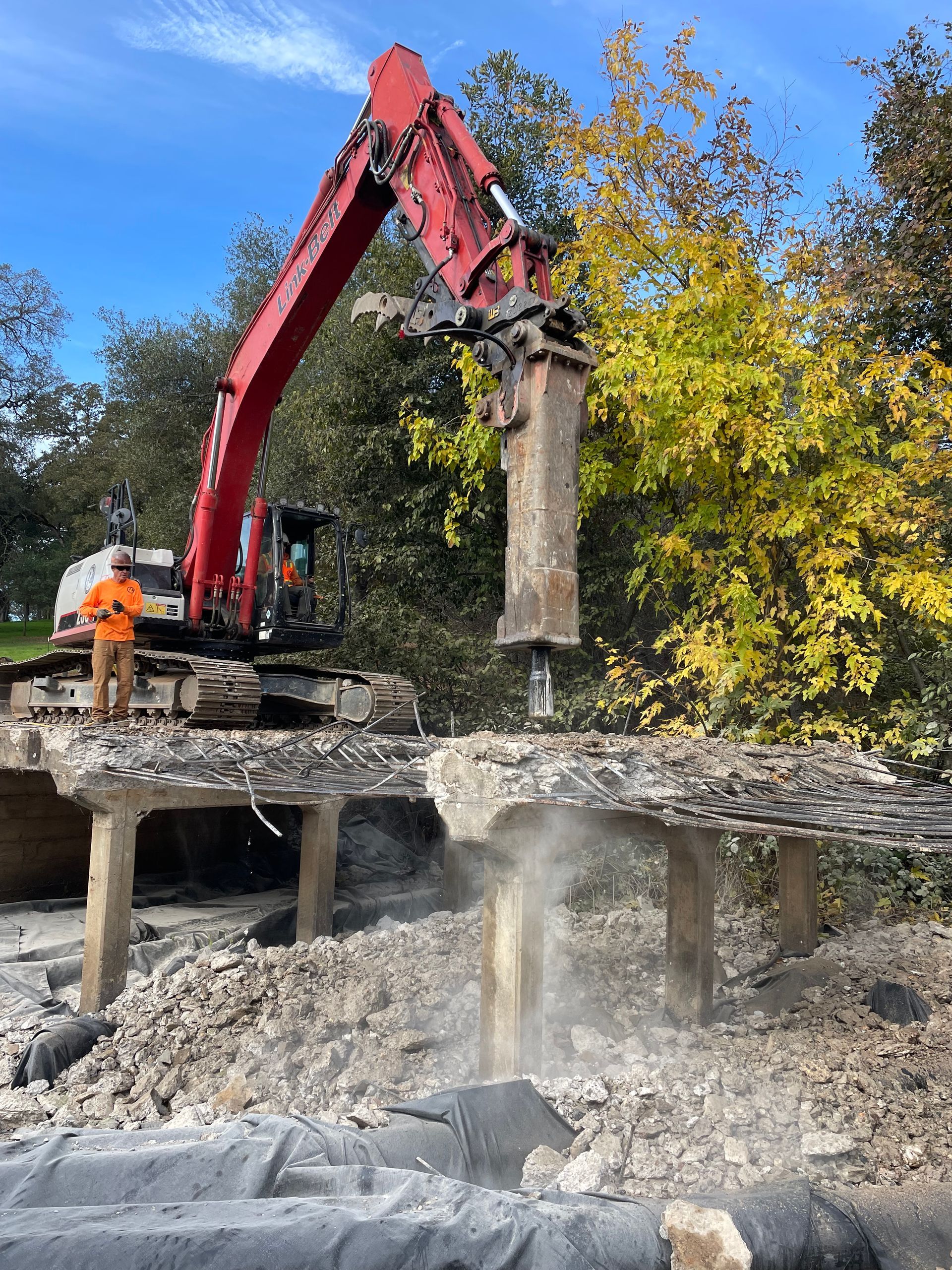 A Large Red Excavator Is Demolishing a Bridge — Chicago, IL — Sterling Holloway Demolition