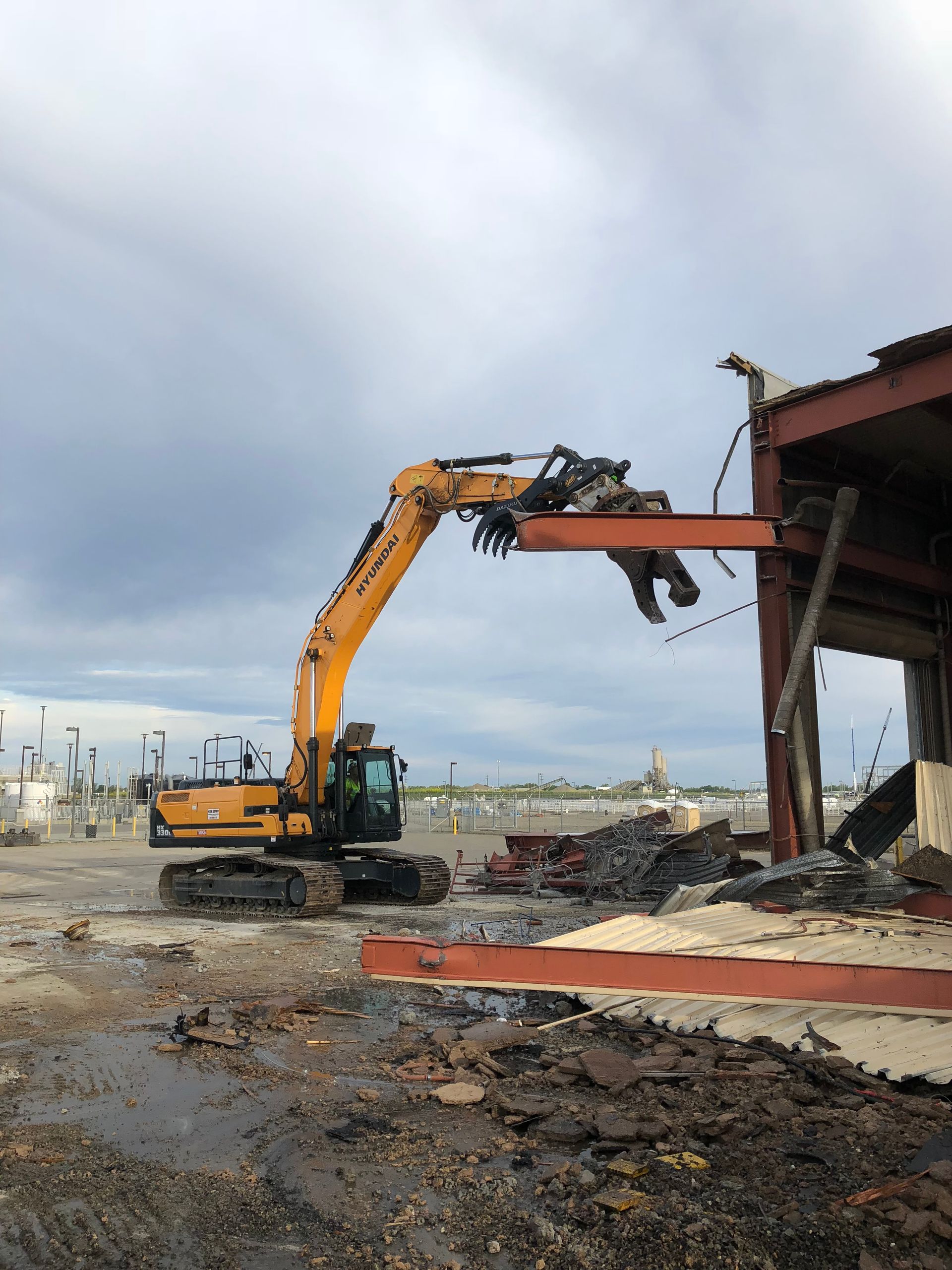 A Large Yellow Excavator Is Demolishing a Building — Chicago, IL — Sterling Holloway Demolition