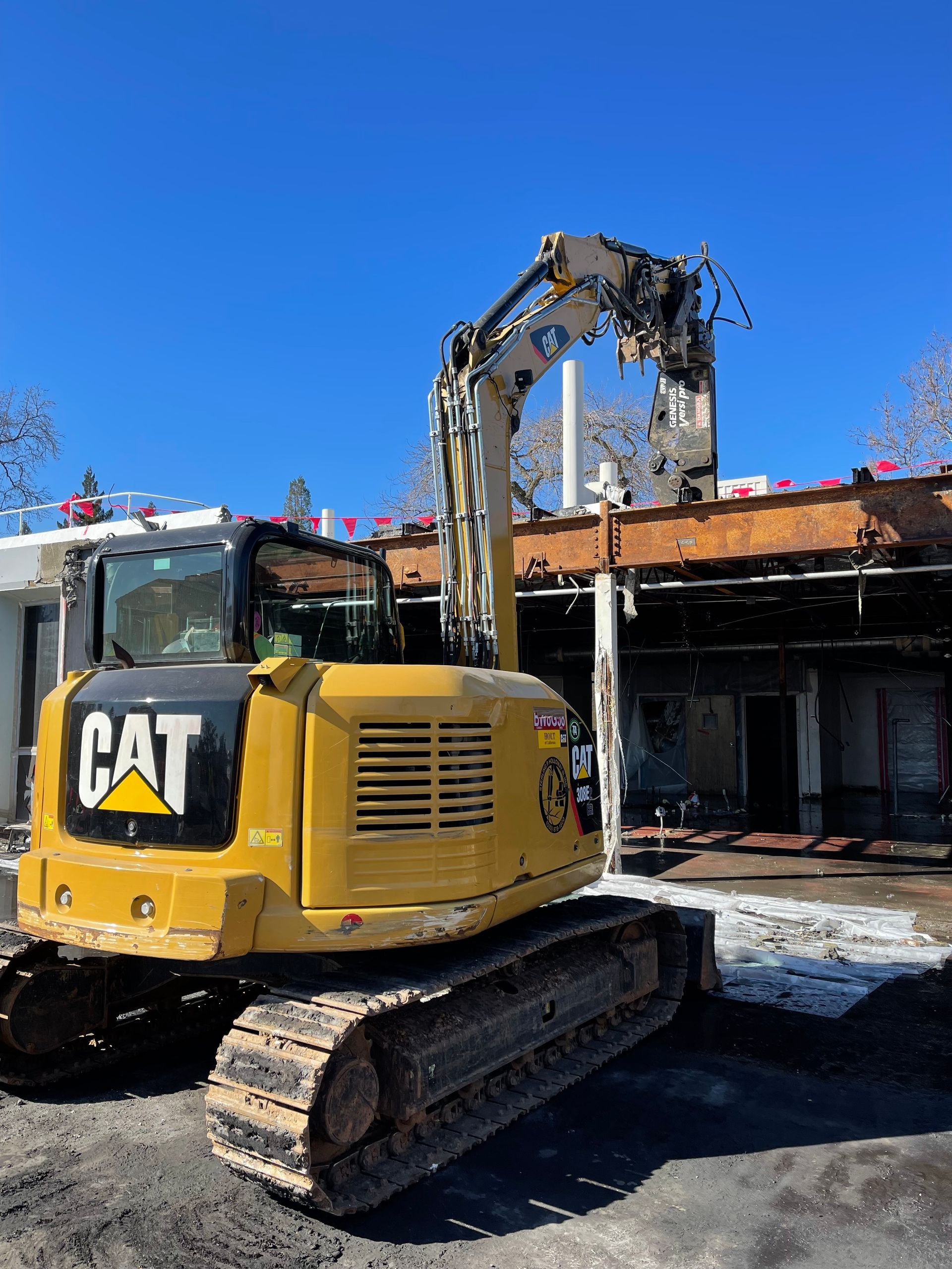 A Yellow Excavator Is Being Used to Demolish a Building — Chicago, IL — Sterling Holloway Demolition