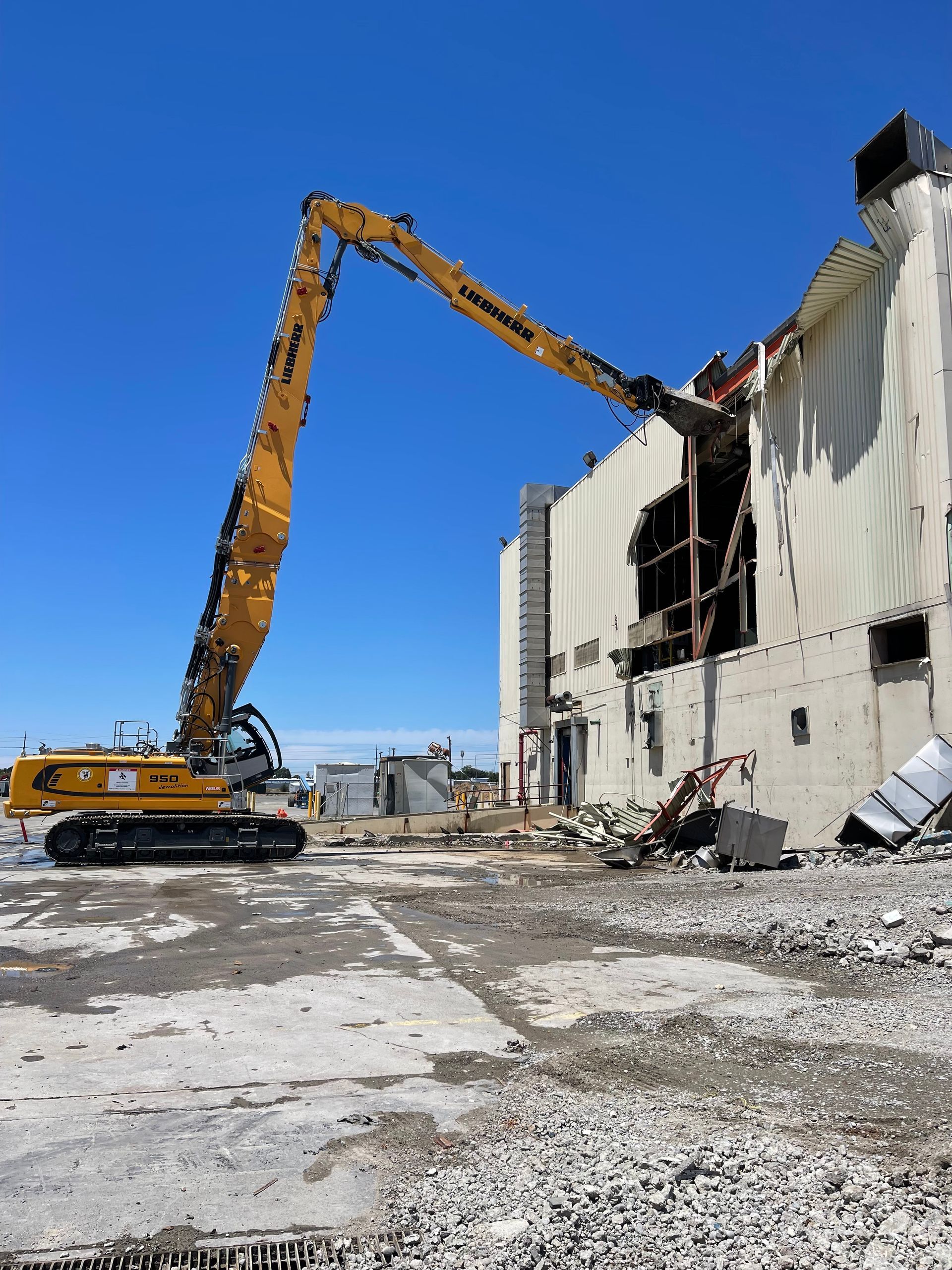 A Large Yellow Excavator Is Demolishing a Building — Chicago, IL — Sterling Holloway Demolition