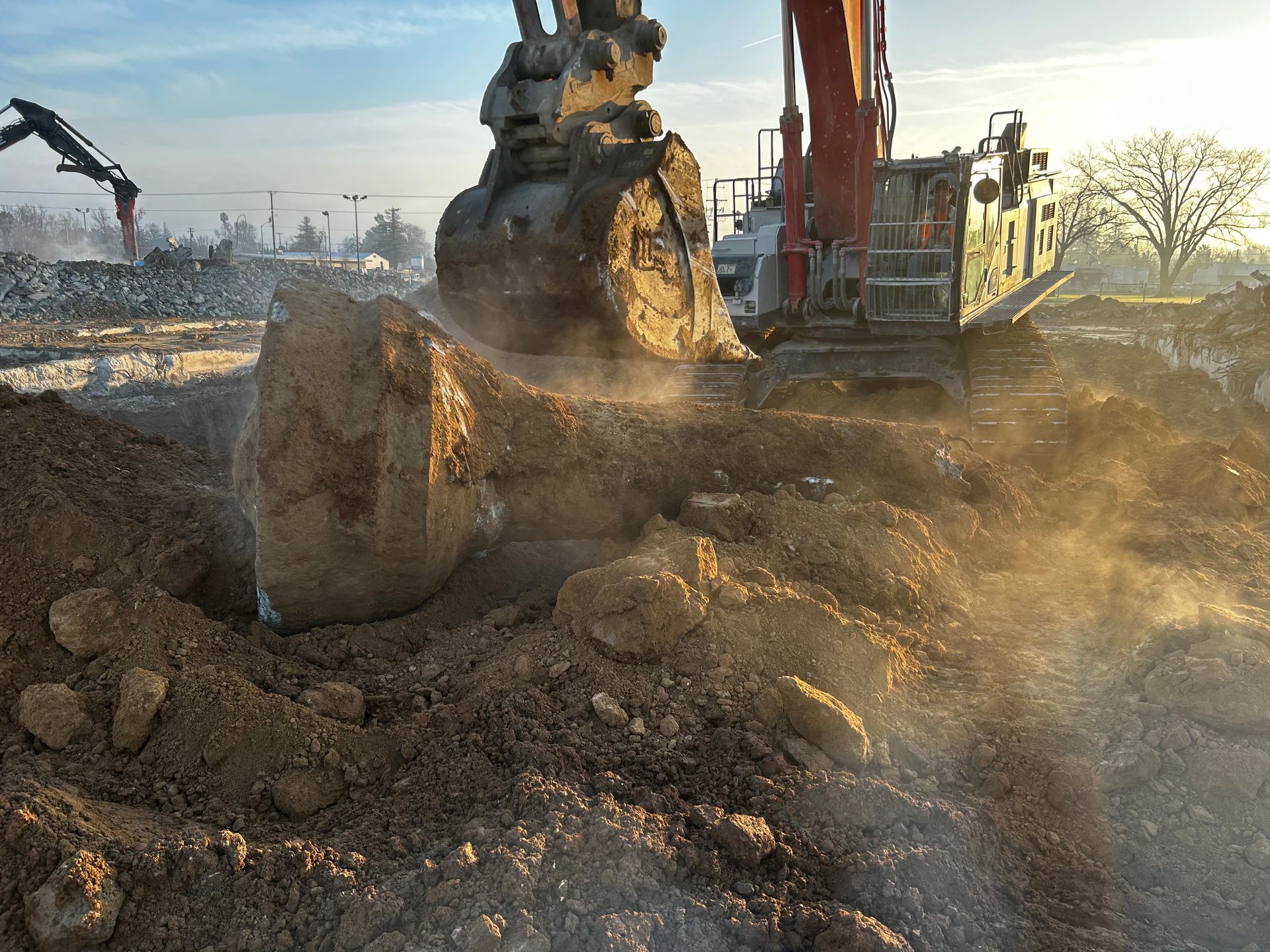 A Large Excavator Is Digging a Hole in the Ground — Chicago, IL — Sterling Holloway Demolition