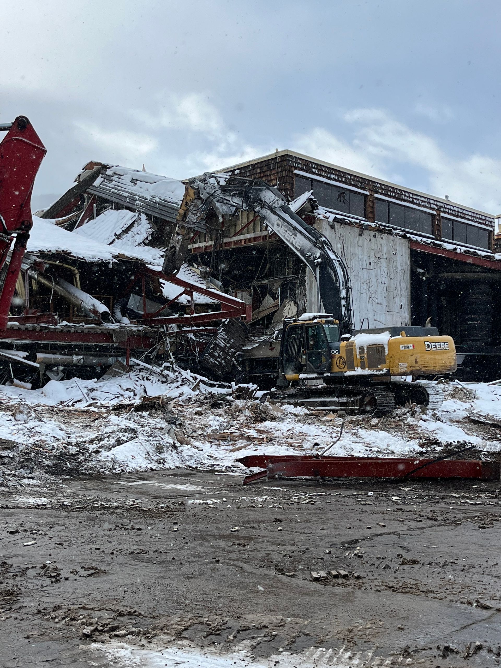 A Large Building Is Being Demolished by a Bulldozer in the Snow — Chicago, IL — Sterling Holloway Demolition