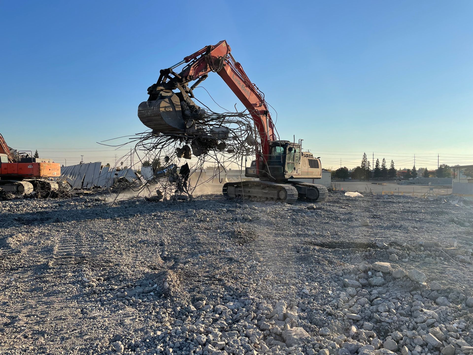 A Large Excavator Is Working on a Gravel Road — Chicago, IL — Sterling Holloway Demolition
