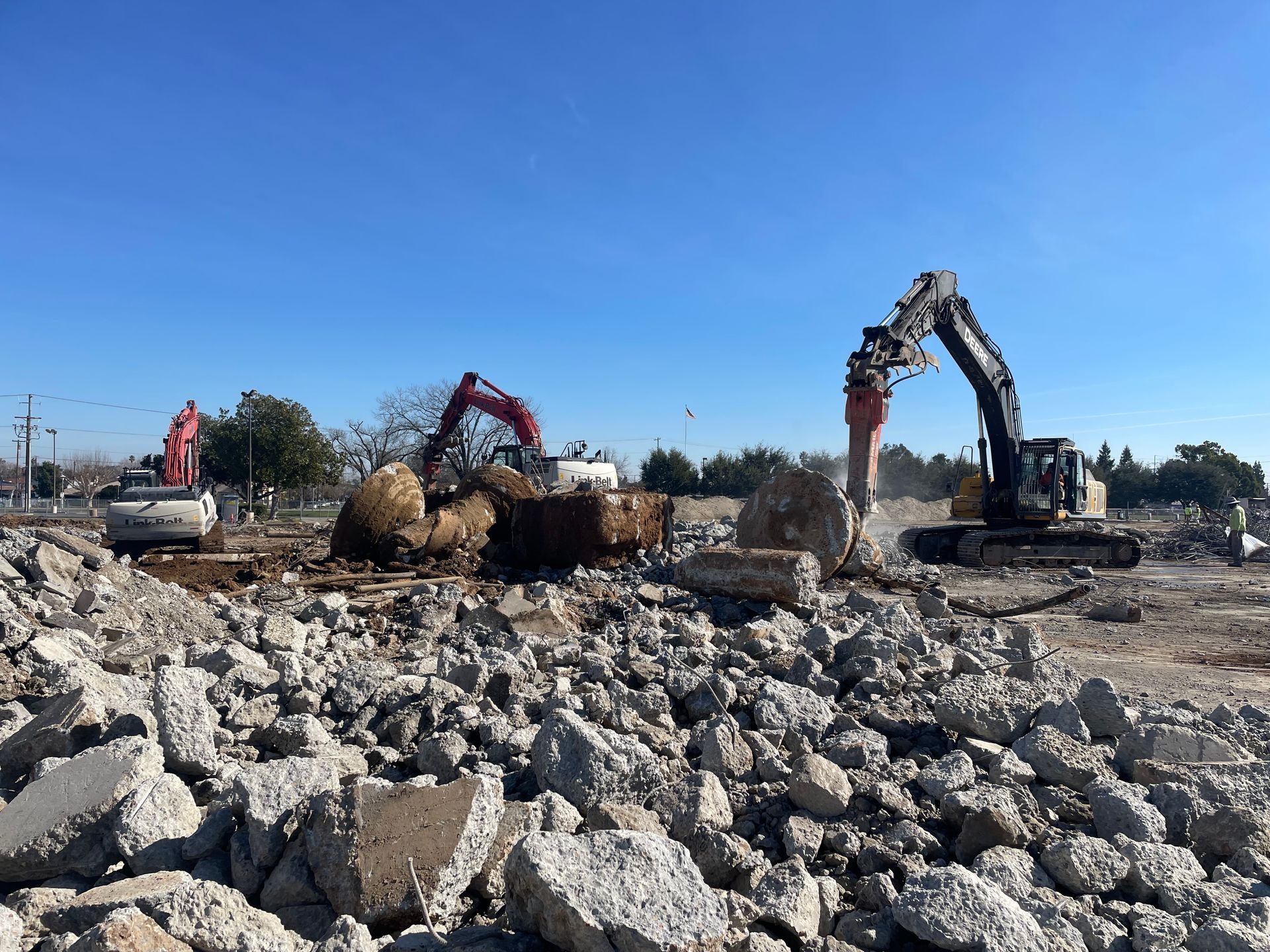 A Construction Site With a Pile of Rocks and a Couple of Excavators — Chicago, IL — Sterling Holloway Demolition