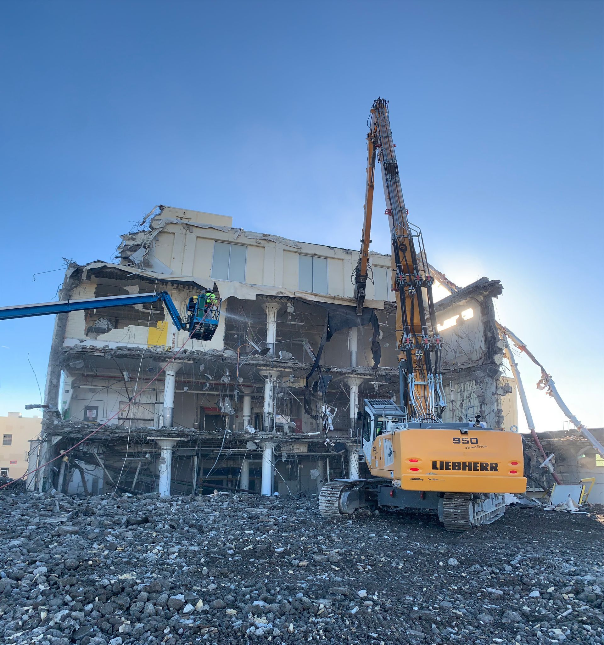 A Large Building Is Being Demolished by a Yellow Excavator — Chicago, IL — Sterling Holloway Demolition