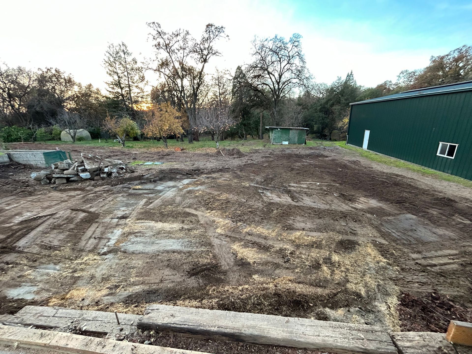 A Large Dirt Field with a Green Building in the Background  — Chicago, IL — Sterling Holloway Demolition 
