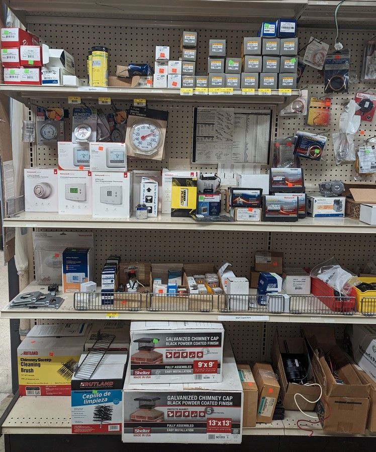 A shelf in a store with boxes of HVAC supplies on it.
