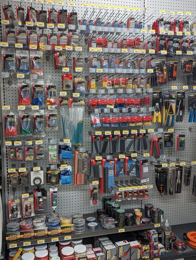 A wall filled with lots of electrical supplies in a store.
